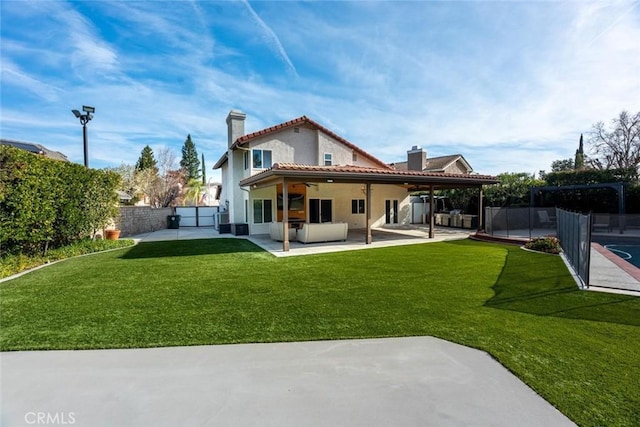 back of house with a patio area and a lawn