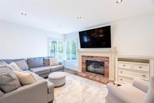 living room featuring a brick fireplace and light hardwood / wood-style floors