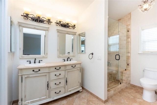 bathroom featuring a shower with door, vanity, tile patterned floors, and toilet