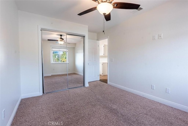 unfurnished bedroom with ceiling fan, carpet flooring, and a closet