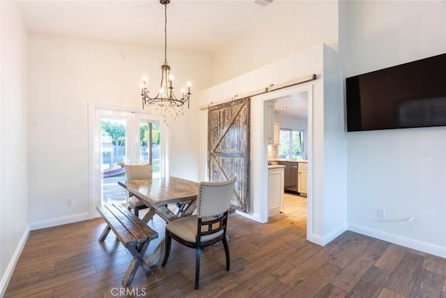 dining space with a notable chandelier, dark wood-type flooring, and a barn door