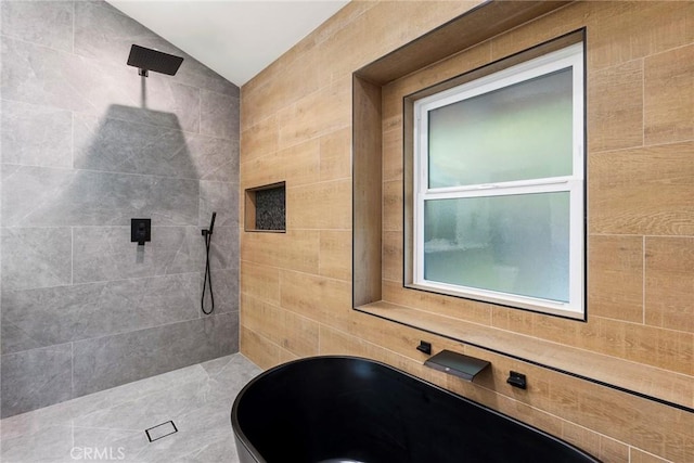 bathroom with vaulted ceiling, sink, and a tile shower