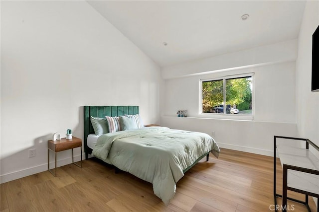 bedroom featuring lofted ceiling and light hardwood / wood-style flooring