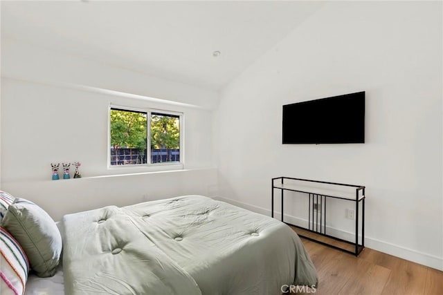 bedroom with lofted ceiling and light wood-type flooring