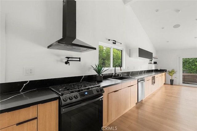 kitchen with black range with gas cooktop, sink, stainless steel dishwasher, plenty of natural light, and wall chimney range hood