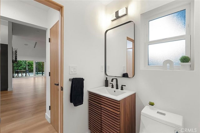 bathroom with vanity, wood-type flooring, and toilet