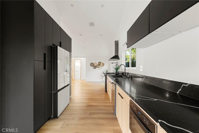 kitchen featuring wall chimney exhaust hood, sink, fridge, dishwasher, and light hardwood / wood-style floors