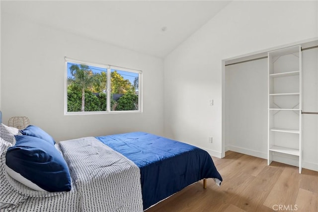 bedroom featuring lofted ceiling and light wood-type flooring