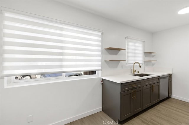 kitchen featuring dishwasher, plenty of natural light, sink, and light hardwood / wood-style floors