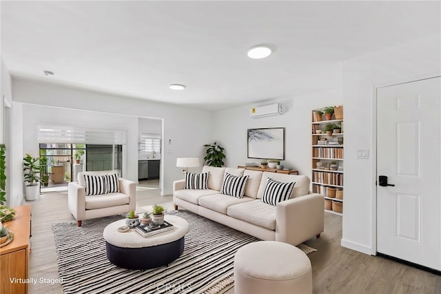 living room with light hardwood / wood-style floors and a wall unit AC