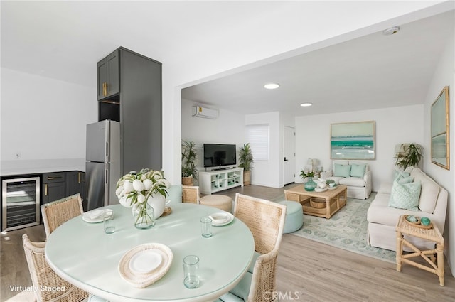 dining area with wine cooler, light hardwood / wood-style flooring, and a wall mounted AC