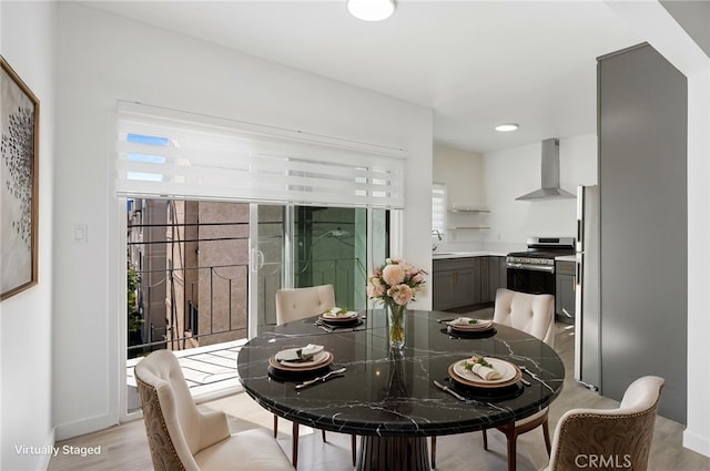 dining space with sink, a wealth of natural light, and light wood-type flooring