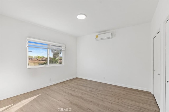 empty room with light hardwood / wood-style flooring and a wall mounted AC