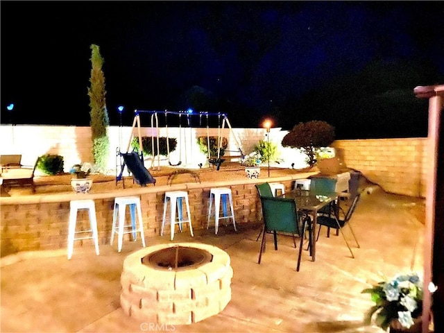 patio at twilight featuring exterior bar and a fire pit