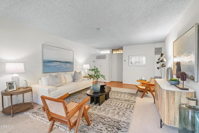 carpeted living room featuring a textured ceiling