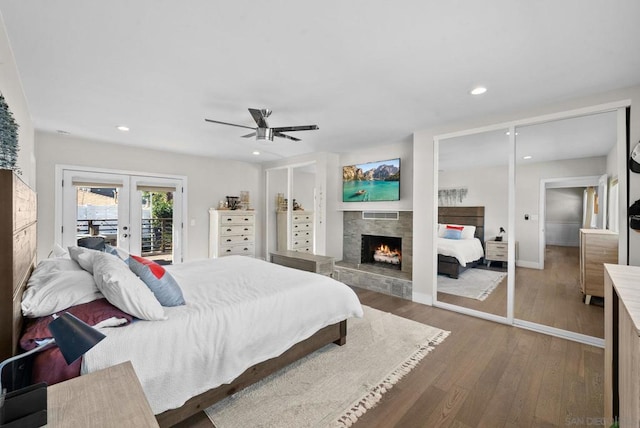 bedroom with ceiling fan, access to exterior, hardwood / wood-style floors, french doors, and multiple closets