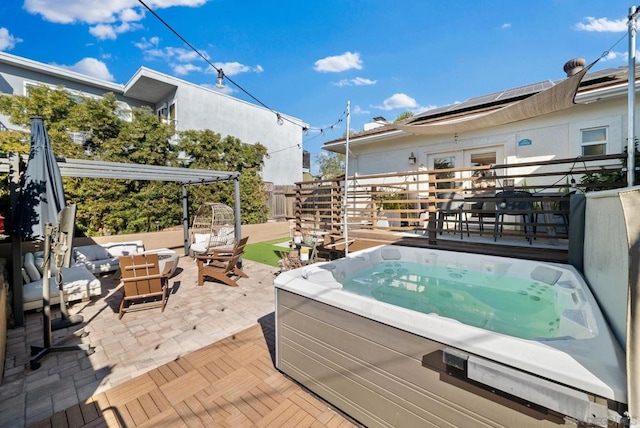 view of patio / terrace with a hot tub, an outdoor hangout area, and a pergola