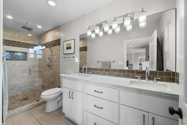 bathroom with tasteful backsplash, tile patterned flooring, vanity, an enclosed shower, and toilet