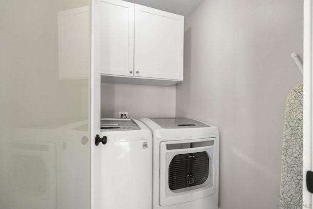 washroom with washing machine and dryer and cabinets