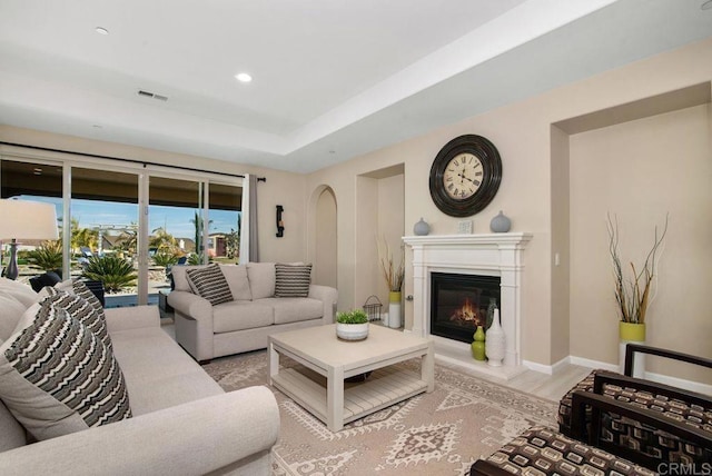 living room featuring light hardwood / wood-style flooring and a tray ceiling