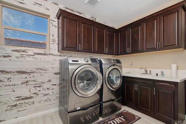 clothes washing area featuring cabinets, separate washer and dryer, and sink