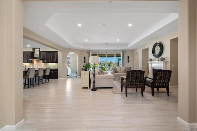 living room with light hardwood / wood-style flooring and a tray ceiling