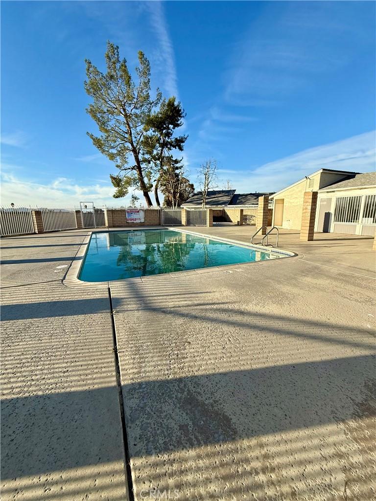 community pool featuring fence and a patio