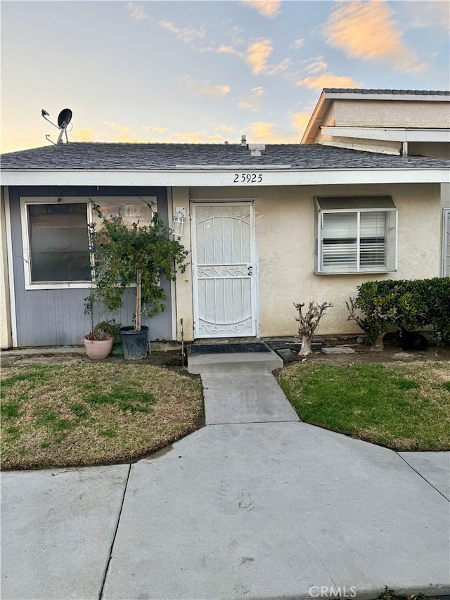 25925 Baylor Way, Hemet, CA 92544 - exterior entry at dusk with a shingled roof and stucco siding
