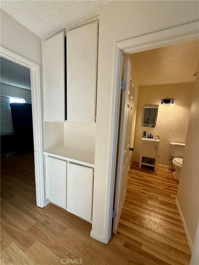 25925 Baylor Way, Hemet, CA 92544 - hall with light wood-style flooring, baseboards, and a textured ceiling