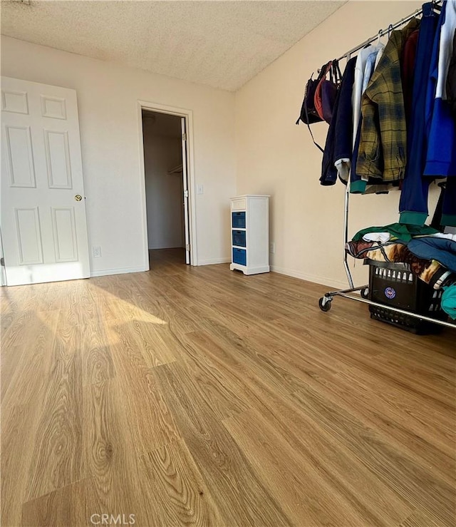 25925 Baylor Way, Hemet, CA 92544 - unfurnished bedroom featuring a textured ceiling, a closet, a spacious closet, wood finished floors, and baseboards