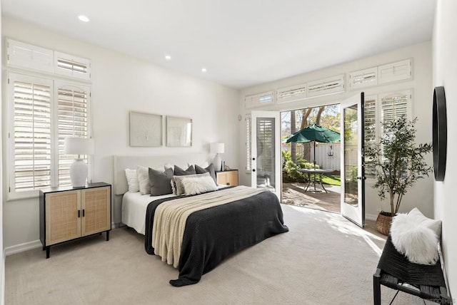 bedroom with multiple windows, access to outside, and light colored carpet