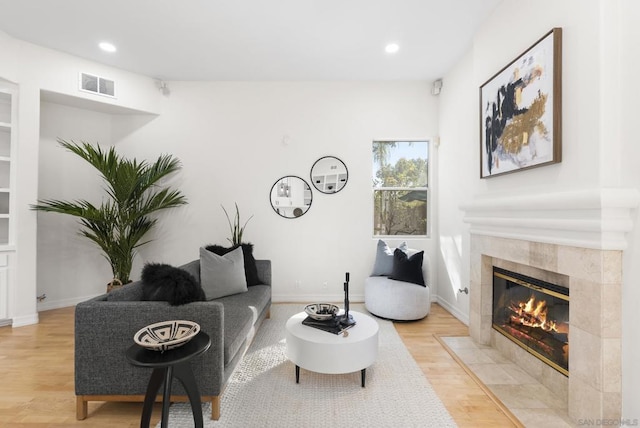 living room featuring light hardwood / wood-style floors and a tile fireplace