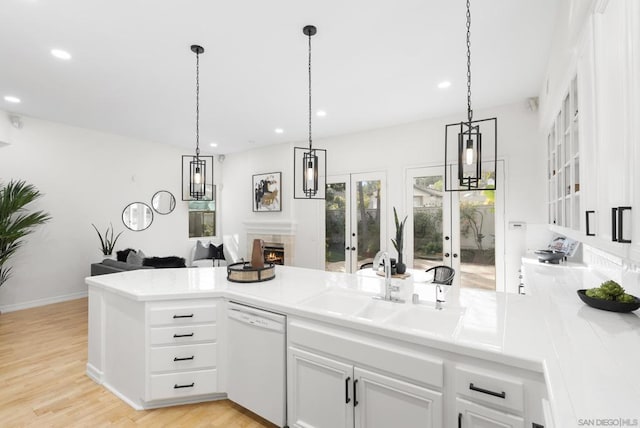 kitchen with sink, white cabinets, hanging light fixtures, white dishwasher, and french doors