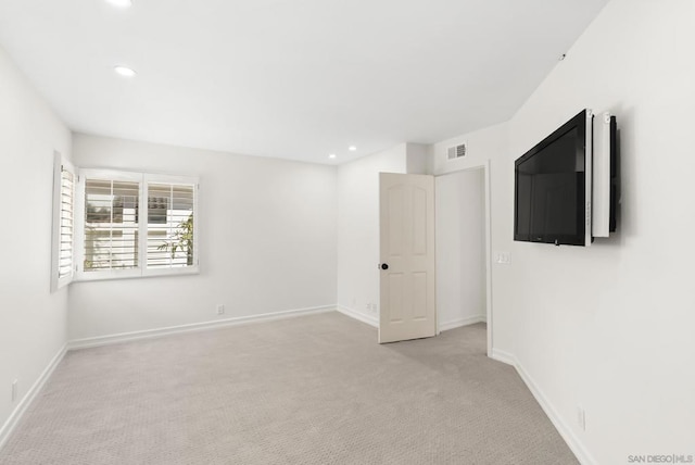 unfurnished room featuring light carpet