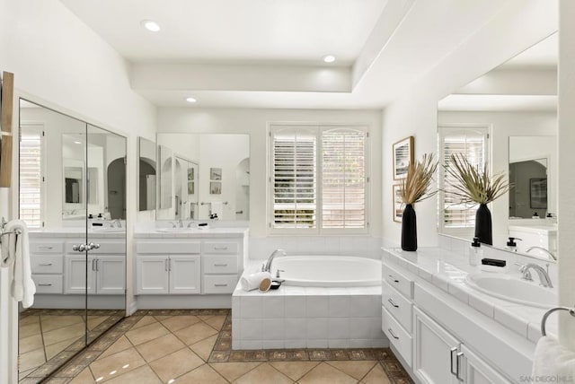 bathroom with vanity, tile patterned floors, and tiled bath