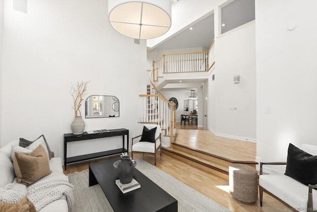 living room featuring a towering ceiling and hardwood / wood-style floors