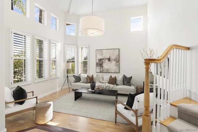 living room featuring a towering ceiling and light hardwood / wood-style flooring