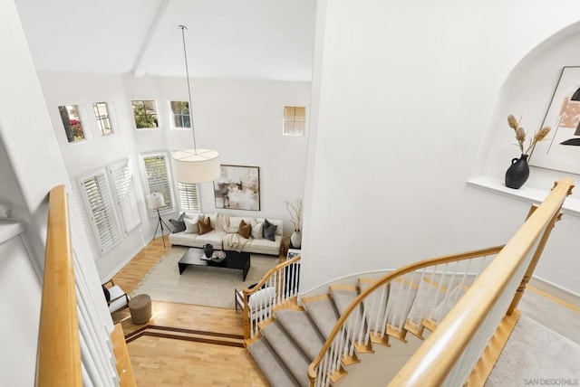 staircase with hardwood / wood-style flooring and a towering ceiling