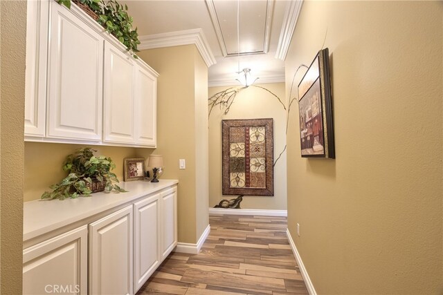 corridor featuring ornamental molding and light hardwood / wood-style floors