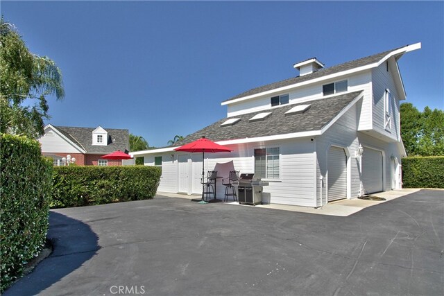 rear view of house featuring a garage