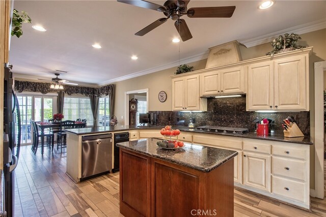 kitchen featuring tasteful backsplash, a center island, dark stone counters, kitchen peninsula, and stainless steel appliances