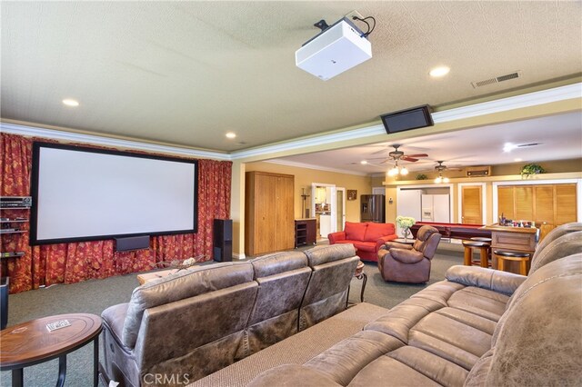 cinema with ornamental molding, ceiling fan, and carpet