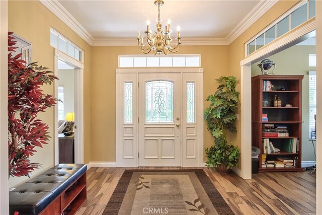 entryway featuring ornamental molding, hardwood / wood-style floors, and a notable chandelier