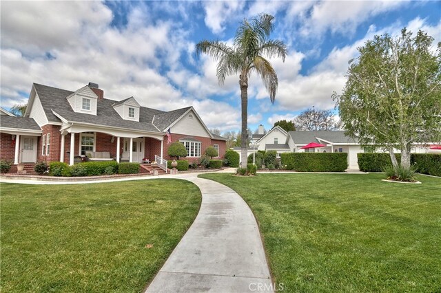 cape cod home with a porch and a front lawn