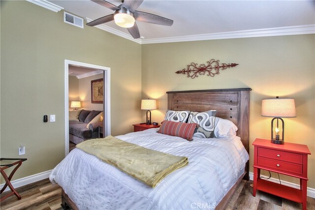 bedroom featuring dark wood-type flooring, ornamental molding, and ceiling fan