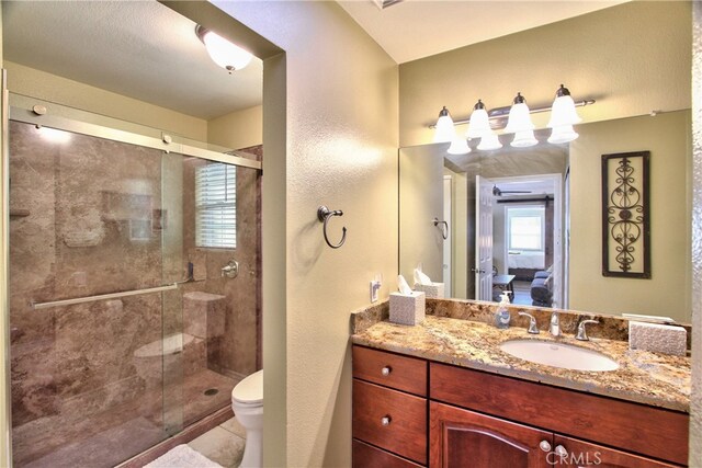 bathroom featuring tile patterned flooring, vanity, an enclosed shower, and toilet