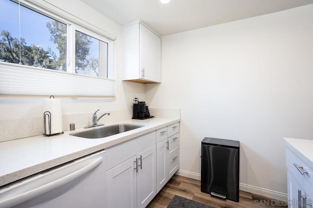 kitchen featuring white dishwasher, sink, dark hardwood / wood-style floors, and white cabinets