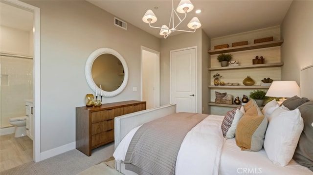 carpeted bedroom featuring a notable chandelier and ensuite bathroom