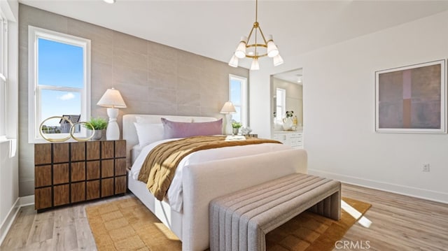 bedroom featuring a notable chandelier and light wood-type flooring