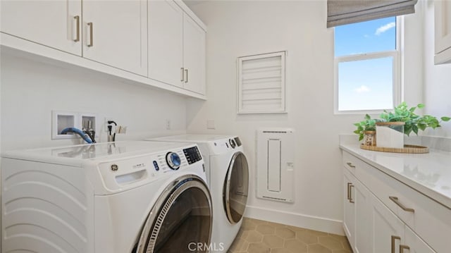 laundry room featuring cabinets, light tile patterned flooring, and separate washer and dryer